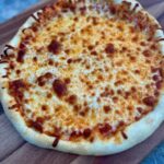 A freshly baked homemade pizza with a golden, crispy crust, melted cheese, and a variety of delicious toppings. The pizza is made with King Arthur Pizza Dough Flour for a light and chewy texture, perfect for family pizza night!