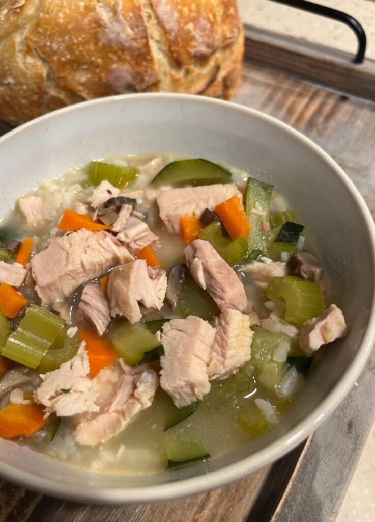 Warm bowl of Savory Turkey Rice & Veggie Soup made with homemade turkey bone broth, rice, and fresh vegetables.