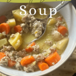 A steaming bowl of Savory Sausage Soup with Potatoes and Carrots, garnished with fresh parsley. The rich broth is filled with slices of sausage, diced potatoes, and tender carrots, showcasing a comforting, hearty meal perfect for cold weather